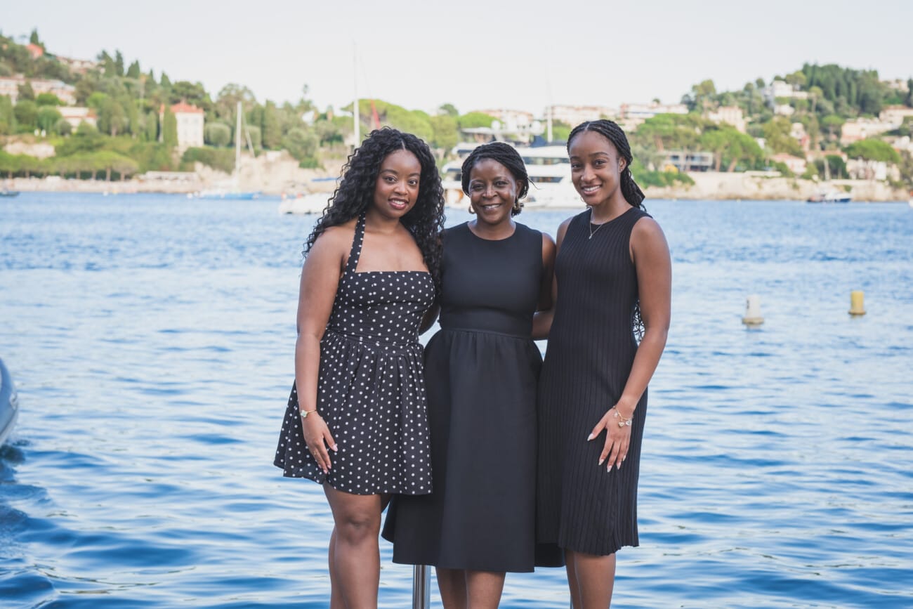 The Ultimate Girls’ Trip: A Mother and Daughters’ Legacy Session on the French Riviera 17 Mother smiling at her two daughters as they walk along the harbor of Villefranche-sur-Mer.